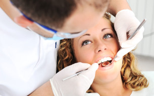 dentist examining a girl's teeth Dental Care Center