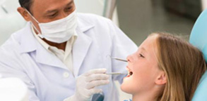 dentist examining a girl's teeth Dental Care Center