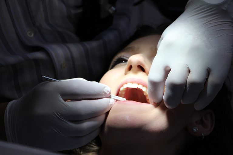 dentist examining girl's teeth Dental Care Center
